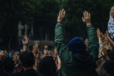 People with arms raised enjoying at music concert