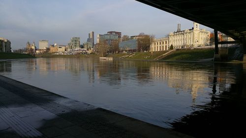 Bridge over river in city against sky