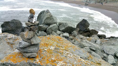 Man on rock at sea shore during winter