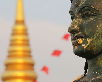 Close-up of buddha statue against building