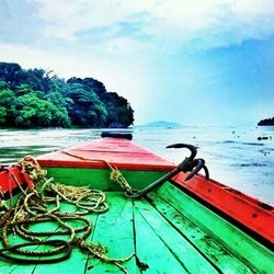 Boats in sea against cloudy sky