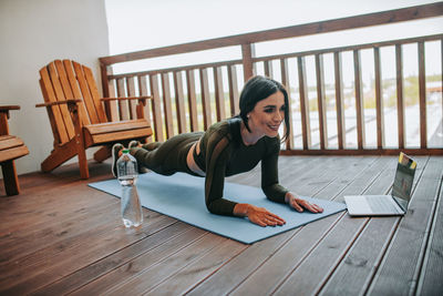 Woman sitting on wooden floor at home