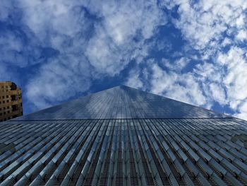 Low angle view of modern buildings against cloudy sky