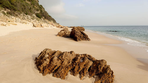 Panoramic view of rocks on beach against sky