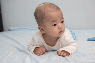 Cute baby boy lying on bed