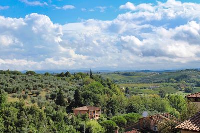 Scenic view of trees and buildings against sky