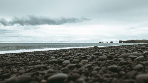 Surface level of pebble beach against sky