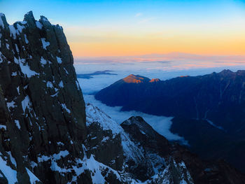 Scenic view of snowcapped mountains against sky during sunset