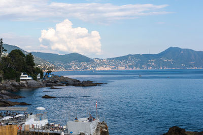 Scenic view of sea by town against sky