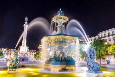 Statue of illuminated fountain at night