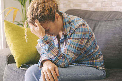 Young man sitting on sofa at home