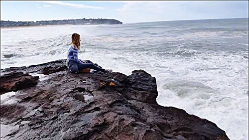 View of calm sea against rocky landscape