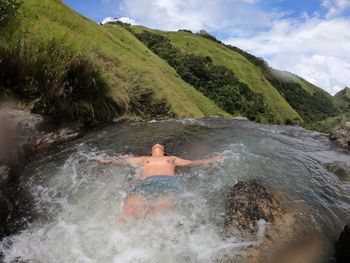 High angle view of shirtless man lying in water