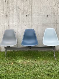 Empty chairs and table against wall