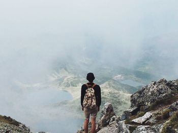 Rear view of young man against foggy landscape