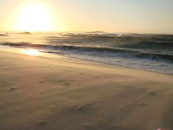 Scenic view of beach against sky during sunset