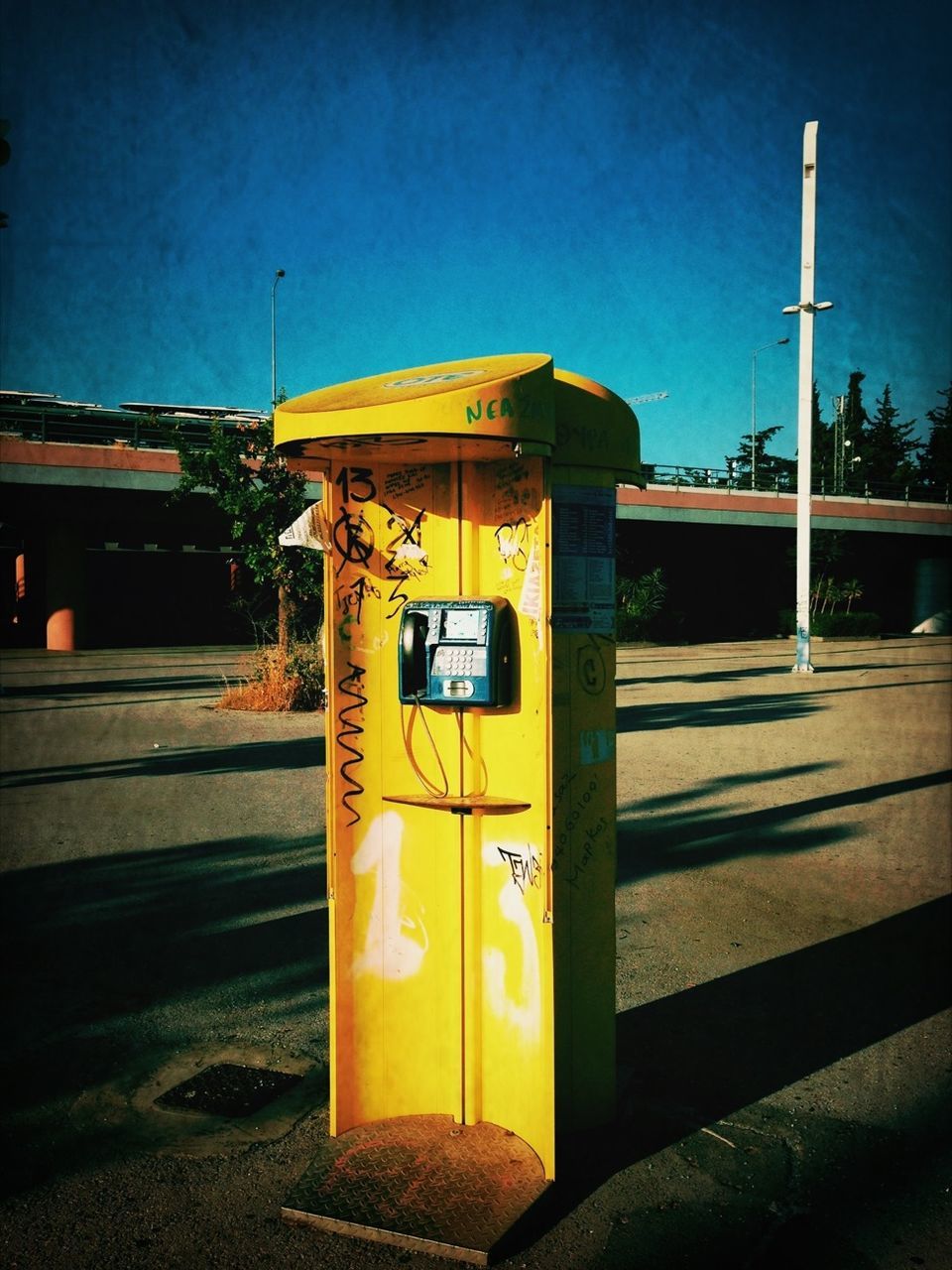 yellow, building exterior, built structure, architecture, street, text, transportation, blue, western script, communication, illuminated, road, clear sky, sidewalk, outdoors, road sign, sky, street light, information sign, no people