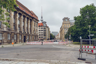 People on street against buildings in city