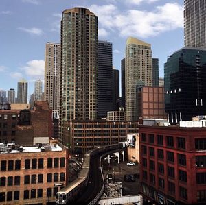 Buildings in city against cloudy sky