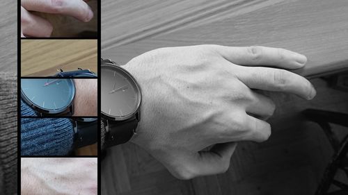 Close-up of hand holding clock against blurred background