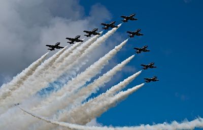 Low angle view of fighter planes flying in blue sky