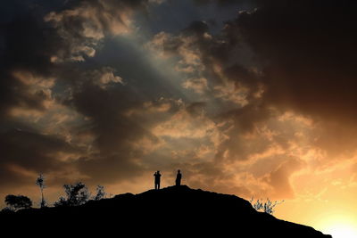 Silhouette of built structure against cloudy sky