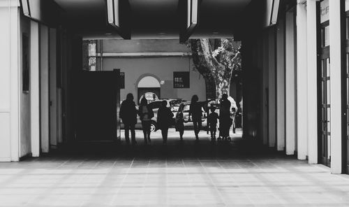 Rear view of people walking in corridor of building