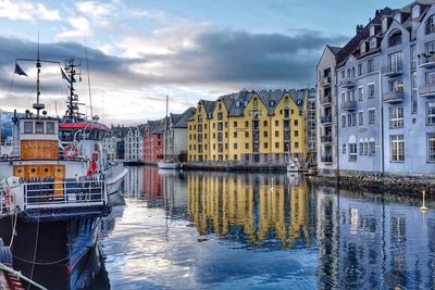 Boats on river by buildings in city