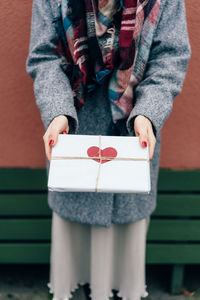 Midsection of woman holding package with heart shape