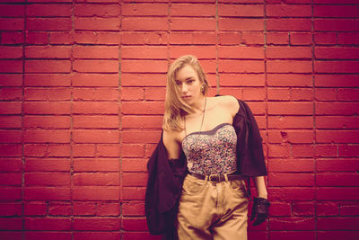 Portrait of young woman standing on wall