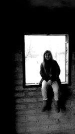 Full length of woman sitting on bench