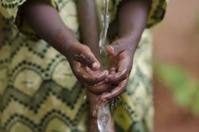 Midsection of child washing hands