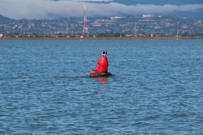 Buoy floating on sea against sky