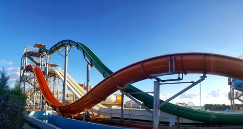 Low angle view of rollercoaster against clear blue sky