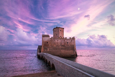 Torre astura in bay of antium against cloudy sky during sunset