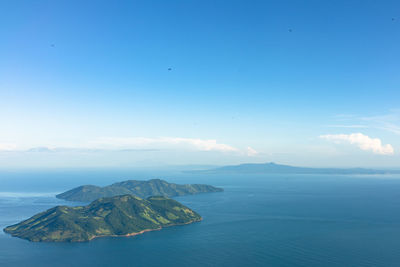 Scenic view of sea and islands against blue sky