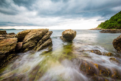 Scenic view of rocks in sea against sky