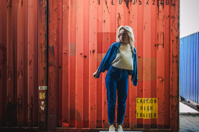 Woman standing against cargo container