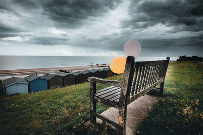 Deck chairs on beach against sky