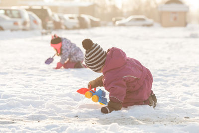 Full length of girl playing in snow