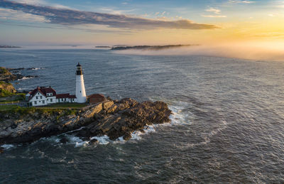 Aerial view of lighthouse by sea against sky