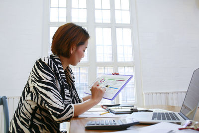 Woman using mobile phone at table
