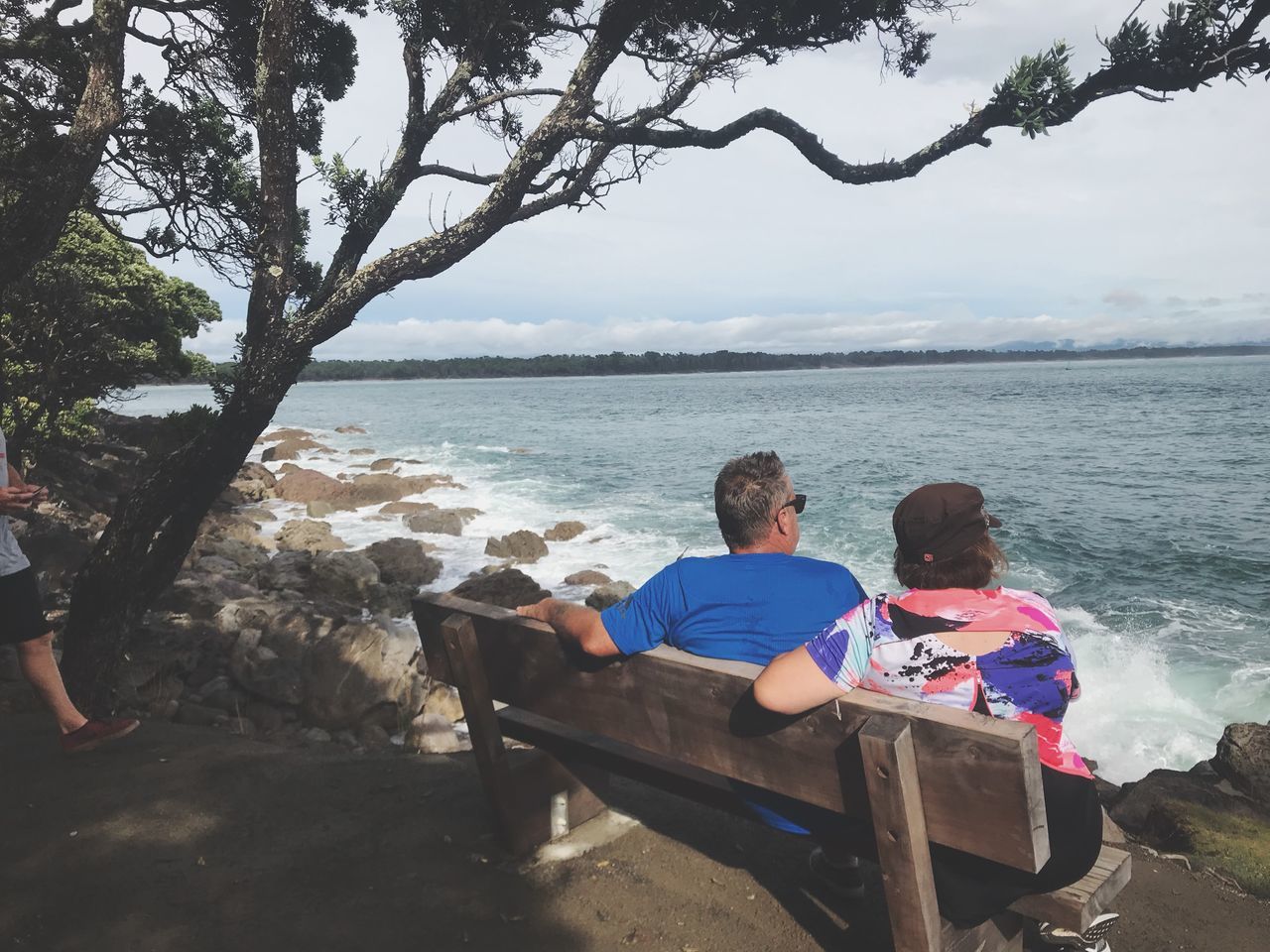 water, sitting, men, real people, sea, togetherness, leisure activity, two people, nature, lifestyles, males, seat, bonding, rear view, casual clothing, people, day, adult, tree, outdoors, positive emotion, couple - relationship