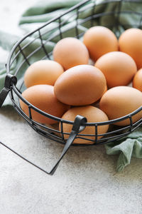 Basket of fresh brown eggs on concrete background