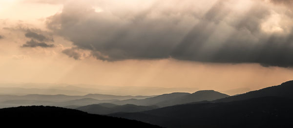 Scenic view of silhouette mountains against sky during sunrise