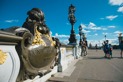 Statue in city against blue sky