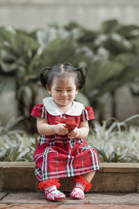 Portrait of smiling girl sitting outdoors