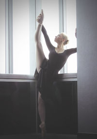 Ballet dancer stretching on floor