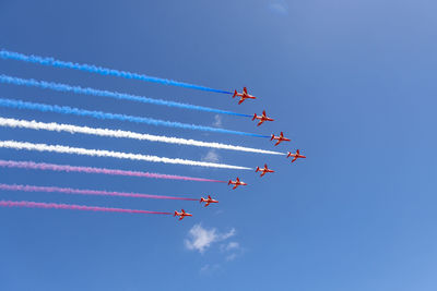 Low angle view of airshow against sky