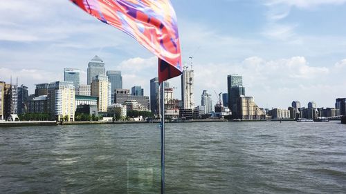 City skyline by river against sky